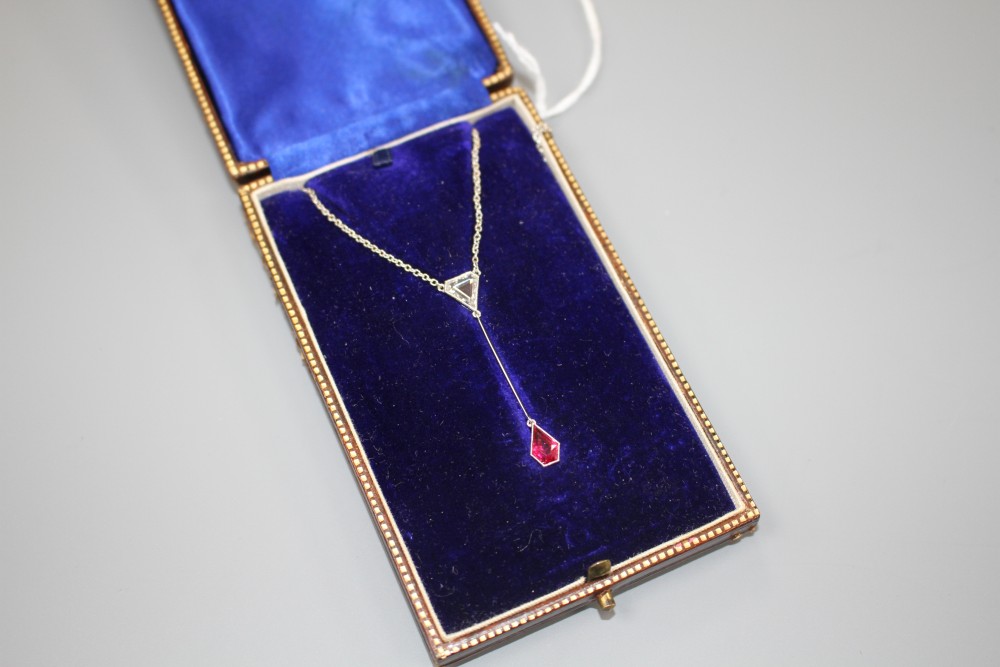 An Art Deco style white metal, ruby and diamond set drop pendant necklace, pendant section 40mm, gross weight 3.9 grams.